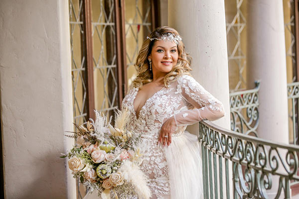plus size bride with tummy problem holding flowers in front on body to hide problem area