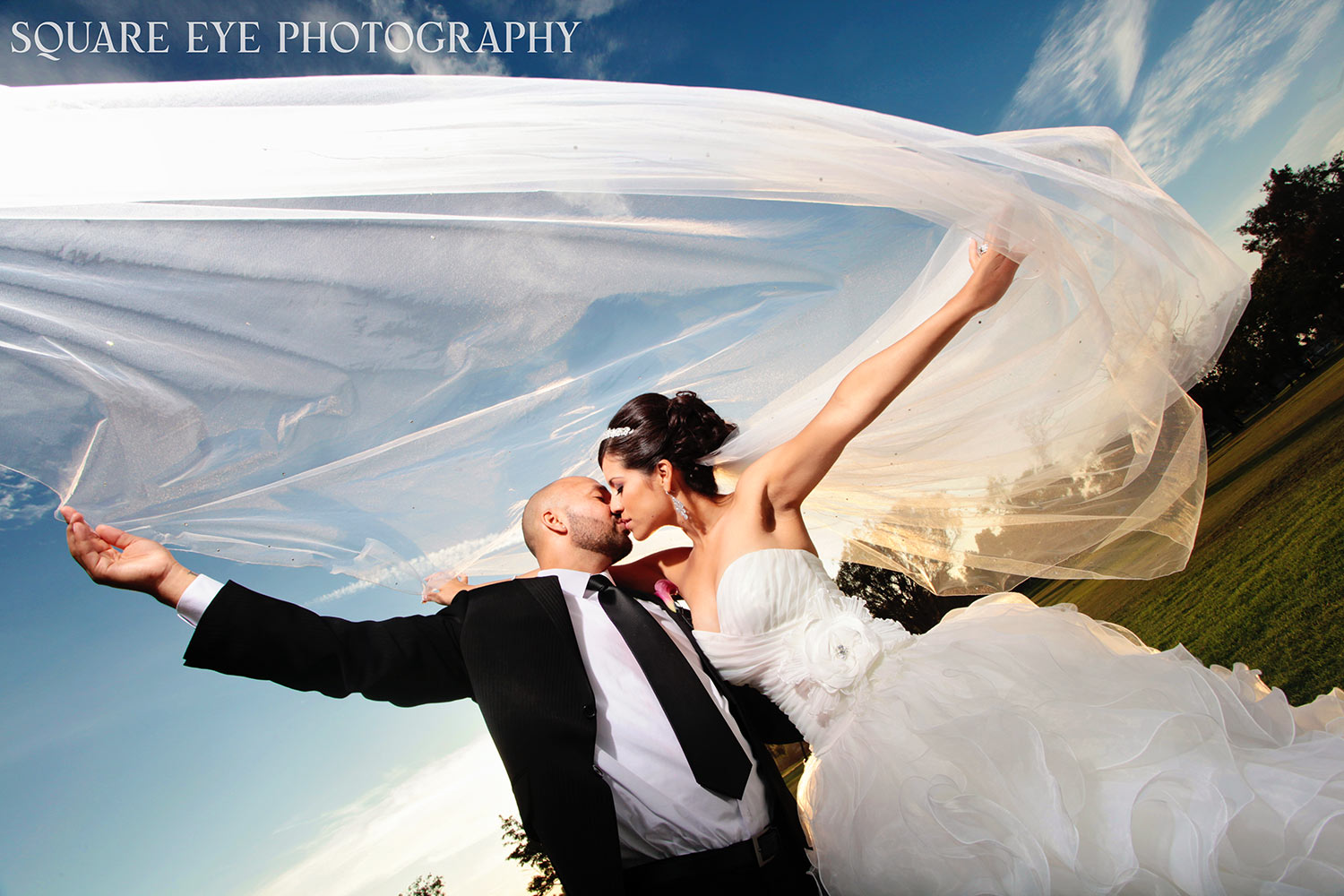 cathedral-veil-sunset-wedding-photos.jpg-01 Cathedral veil wedding photos of a bride with her long veil lifted against the sunset, photographed by Square Eye Photography
